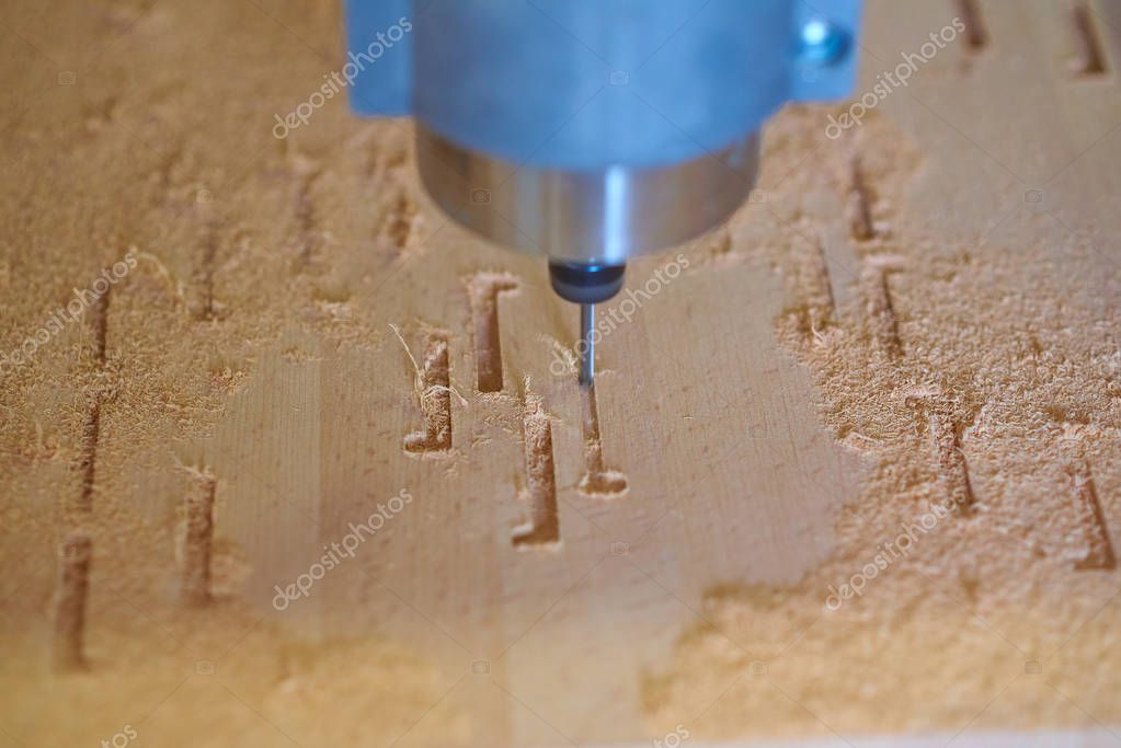 Gravure laser en cours sur une plaque de bois